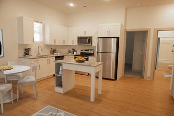 a kitchen with a center island and a stainless steel refrigerator